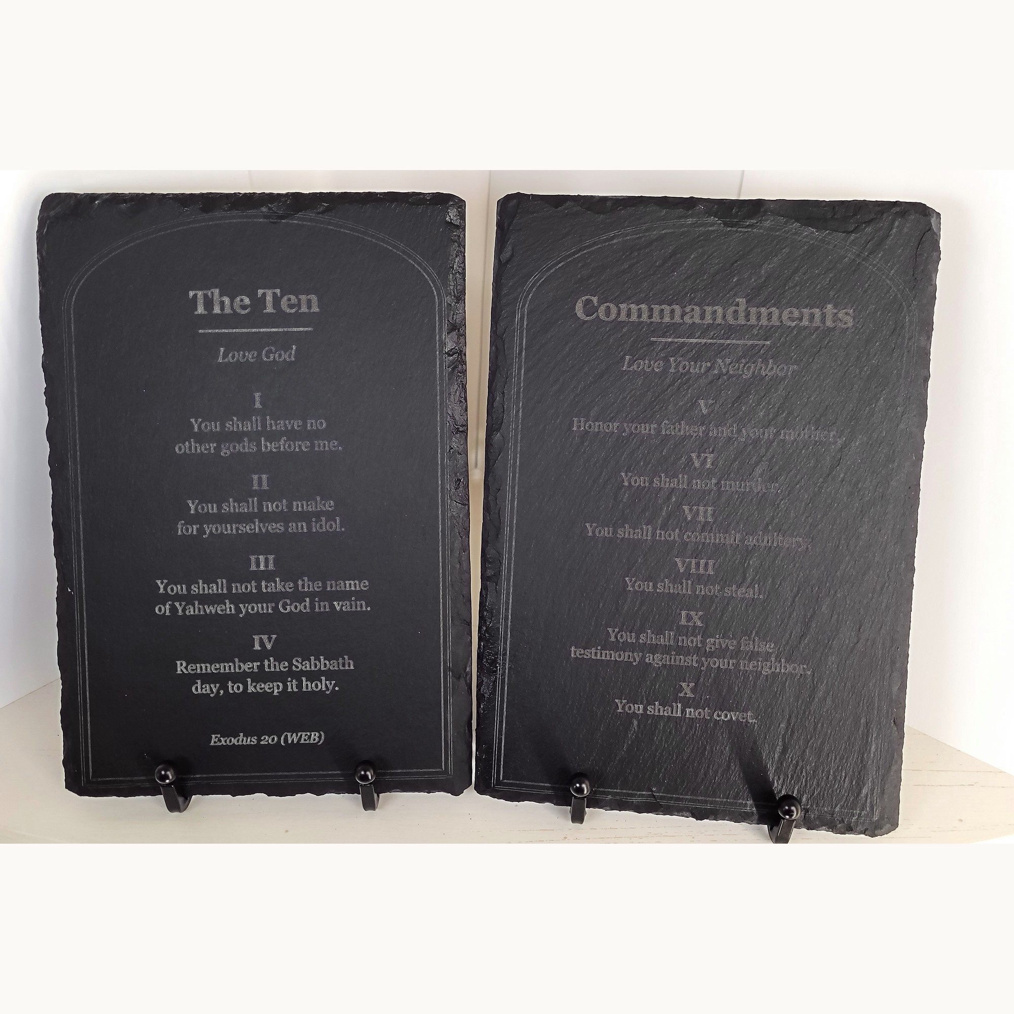 The two slate tablets side by side on their black metal easel stands. The left tablet reads "The Ten", "Love God" and commandments I to IV, ending "Exodus 20 (WEB)". The right reads "Commandments", "Love Your Neighbor" and V to X. The photographed set has no dedication.